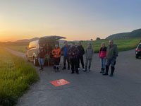 Kitzretter JV NT Nürtingen - Personen stehen vor Bus und schauen der Drohne zu.